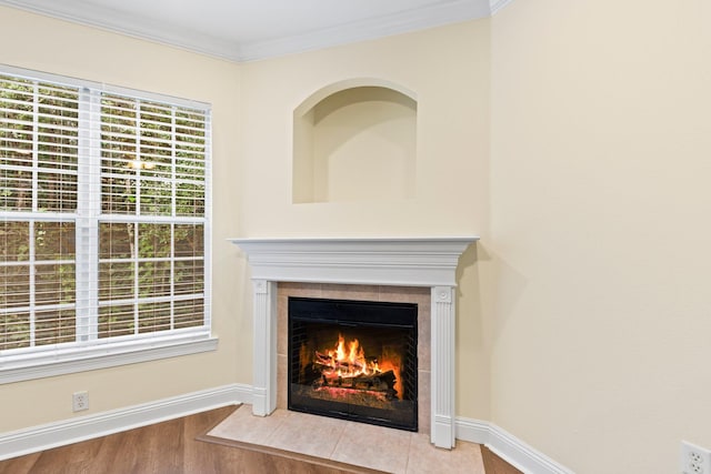 details featuring hardwood / wood-style floors, crown molding, and a tiled fireplace