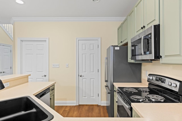 kitchen featuring stainless steel appliances, green cabinets, dark hardwood / wood-style floors, and crown molding