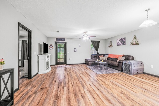 living room with ceiling fan, hardwood / wood-style floors, and a textured ceiling