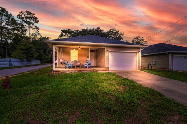 view of front of house with a lawn, a porch, and a garage