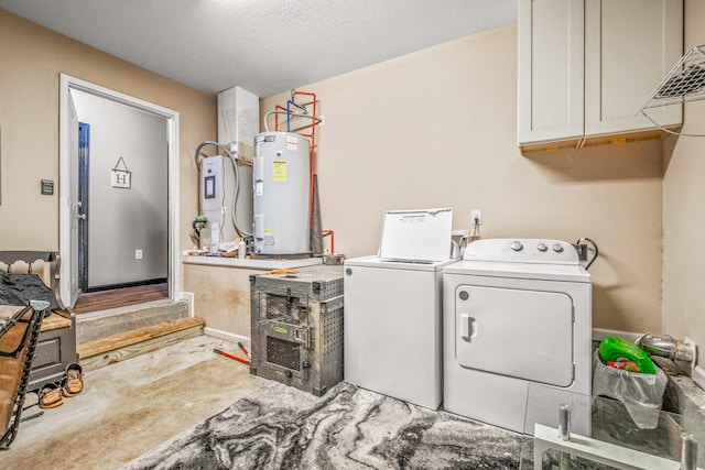 clothes washing area featuring cabinets, water heater, a textured ceiling, and separate washer and dryer