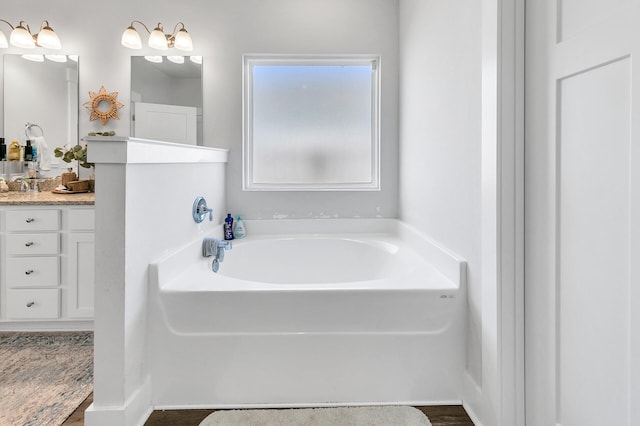 bathroom with vanity, hardwood / wood-style flooring, and a bathtub