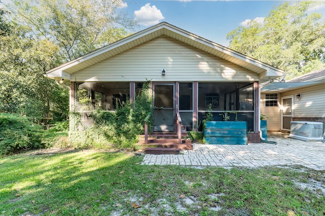 back of house with a sunroom and a lawn