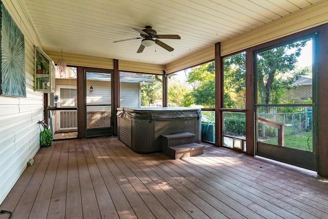 unfurnished sunroom featuring ceiling fan, a hot tub, and a healthy amount of sunlight