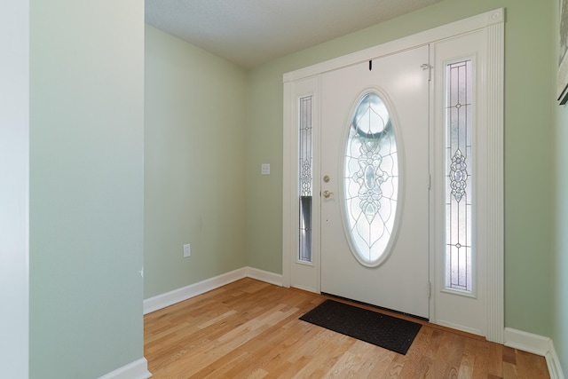 entrance foyer with a textured ceiling and light hardwood / wood-style floors