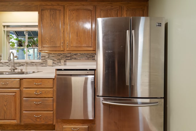 kitchen featuring appliances with stainless steel finishes, sink, and tasteful backsplash