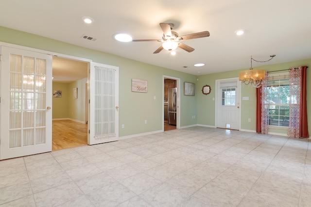 spare room with ceiling fan with notable chandelier