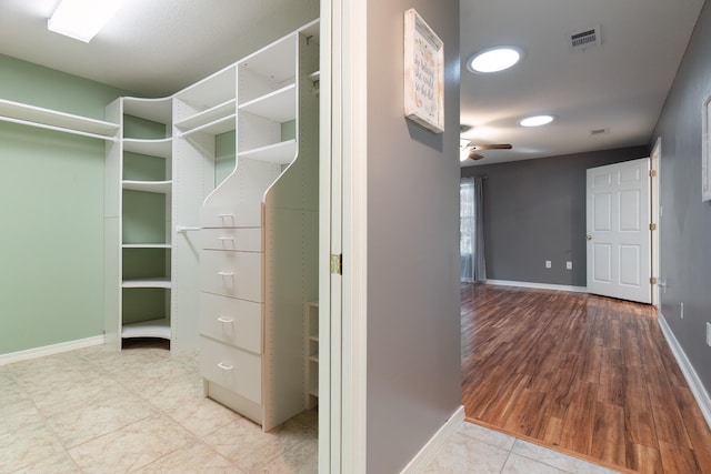 spacious closet featuring ceiling fan and light hardwood / wood-style floors