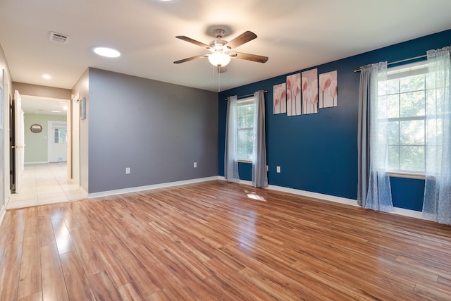 unfurnished room featuring ceiling fan, light hardwood / wood-style floors, and a wealth of natural light