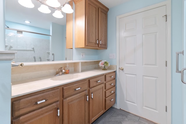 bathroom featuring an enclosed shower, a chandelier, and vanity