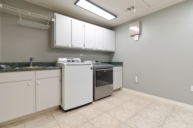 laundry area with cabinets, sink, washing machine and clothes dryer, and light tile patterned flooring