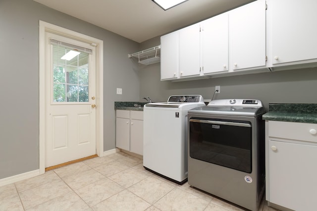 washroom featuring separate washer and dryer, cabinets, and light tile patterned flooring