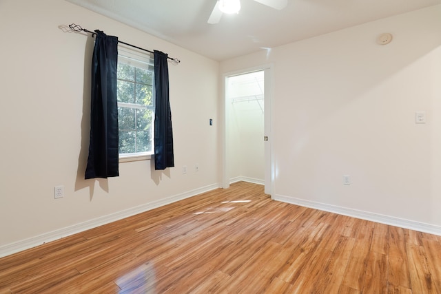 empty room with ceiling fan and light hardwood / wood-style floors