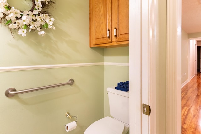 bathroom with hardwood / wood-style flooring and toilet