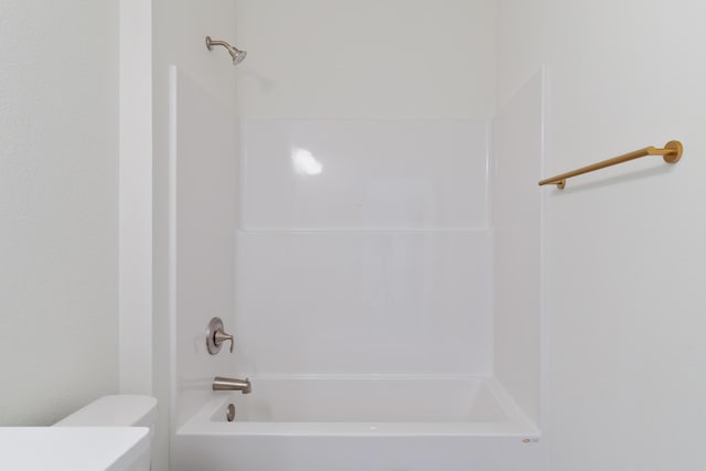 bathroom featuring shower / bathtub combination and toilet