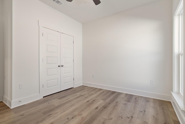 unfurnished bedroom with light hardwood / wood-style flooring, ceiling fan, and a closet