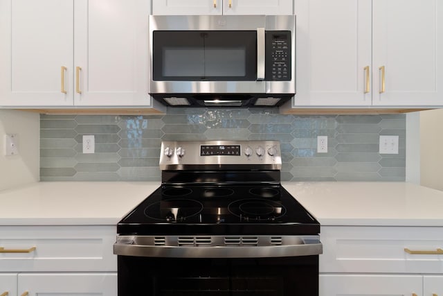 kitchen featuring backsplash, white cabinetry, and electric range