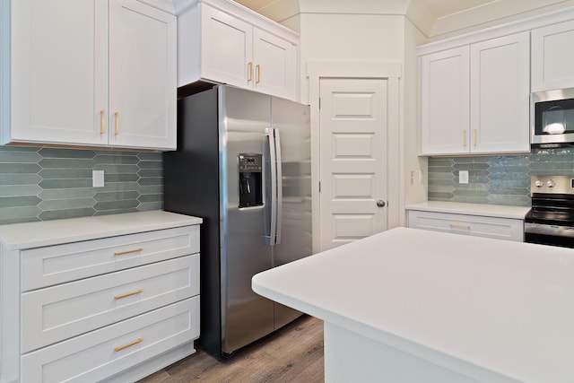 kitchen with white cabinetry, stainless steel appliances, light hardwood / wood-style floors, and decorative backsplash