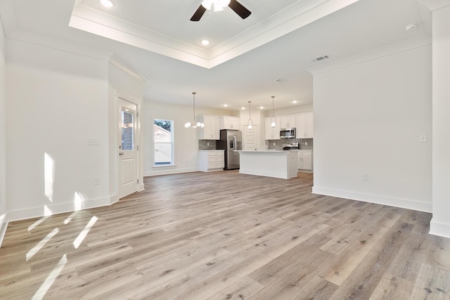 unfurnished living room featuring ornamental molding, ceiling fan with notable chandelier, and light hardwood / wood-style flooring