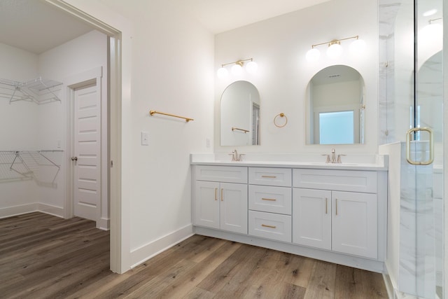 bathroom with hardwood / wood-style flooring, vanity, and walk in shower