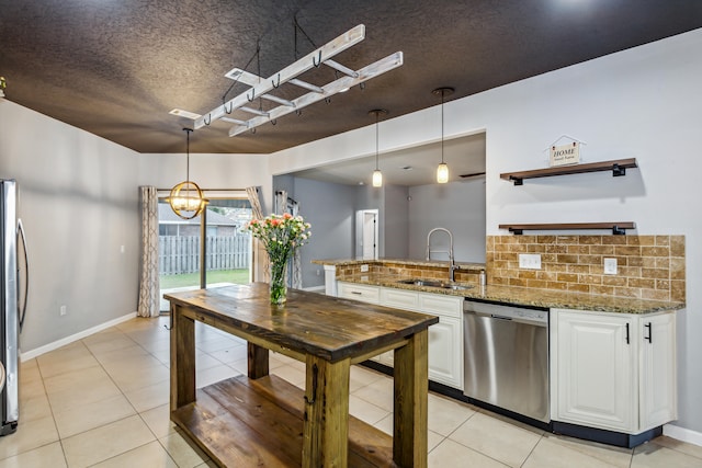 kitchen with tasteful backsplash, white cabinetry, sink, pendant lighting, and stainless steel appliances