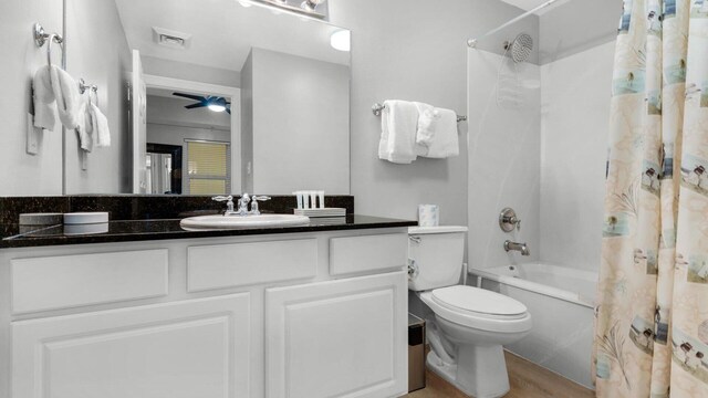 full bathroom with wood-type flooring, shower / tub combo with curtain, ceiling fan, vanity, and toilet