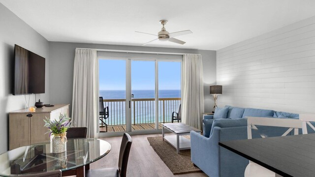 living room featuring ceiling fan, hardwood / wood-style floors, and a water view