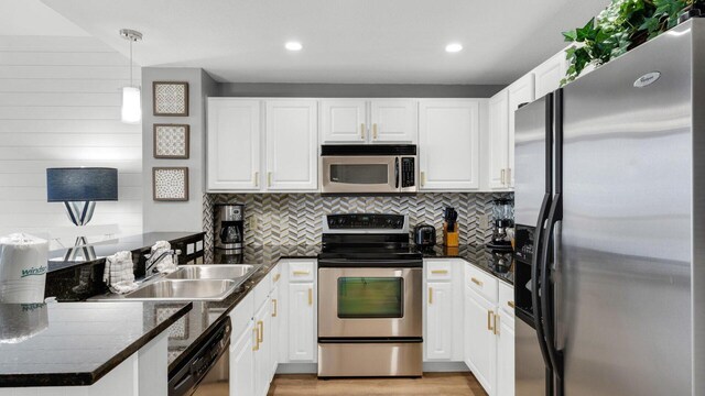 kitchen with pendant lighting, white cabinetry, and appliances with stainless steel finishes