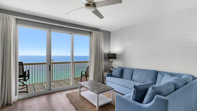 living room with a water view, ceiling fan, and hardwood / wood-style flooring