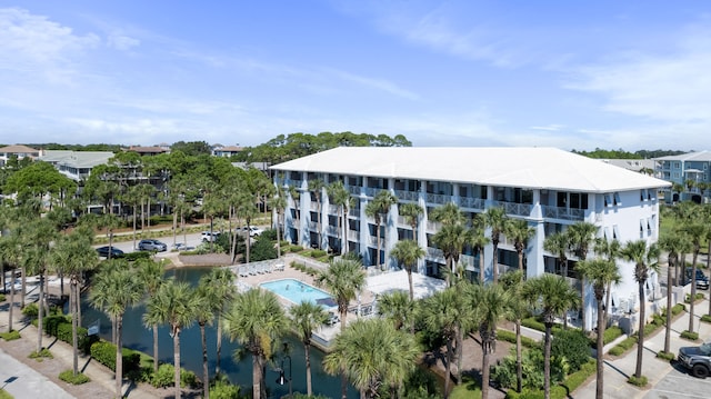 view of building exterior featuring a water view and a community pool