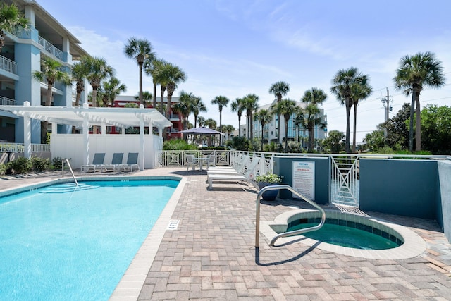 view of pool featuring a patio and a hot tub