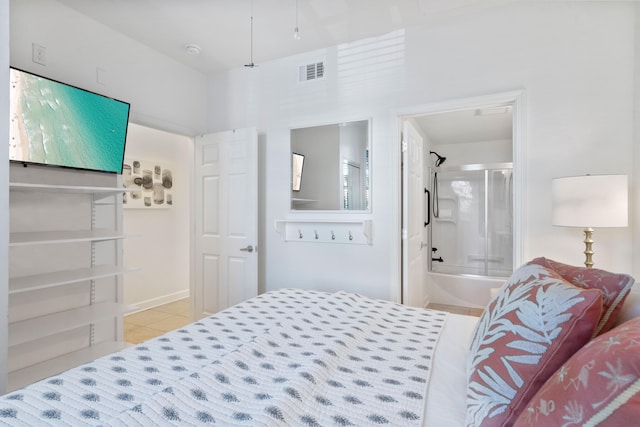 bedroom with ensuite bath and light tile patterned floors