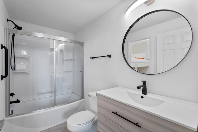 full bathroom with bath / shower combo with glass door, vanity, and toilet