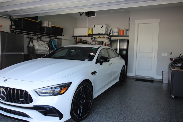 garage featuring a garage door opener and black fridge