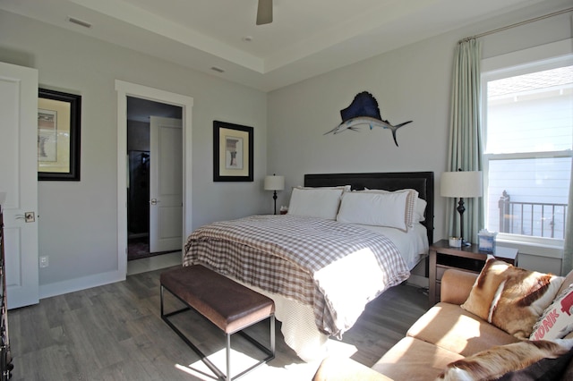 bedroom with ceiling fan, dark hardwood / wood-style flooring, and multiple windows