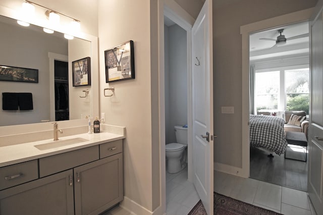 bathroom with wood-type flooring, vanity, toilet, and ceiling fan