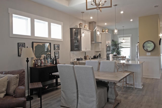 dining area with a notable chandelier, dark wood-type flooring, and a healthy amount of sunlight