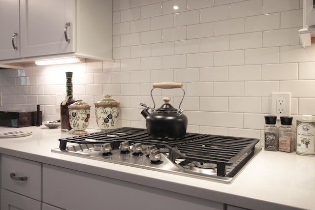 kitchen with gray cabinets, tasteful backsplash, and stainless steel gas cooktop