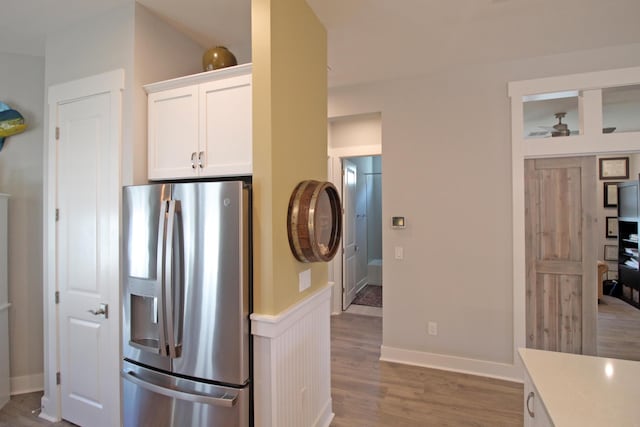 kitchen with white cabinets, wood-type flooring, and stainless steel fridge with ice dispenser