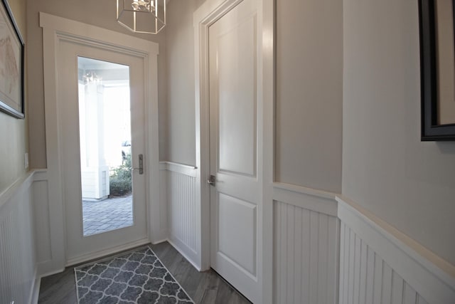 doorway to outside featuring an inviting chandelier and dark hardwood / wood-style floors