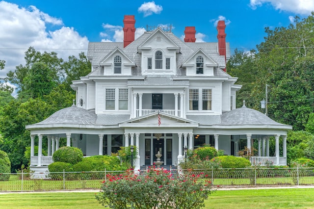 victorian house with a front lawn and covered porch