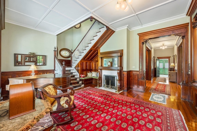 living area with coffered ceiling, hardwood / wood-style flooring, and crown molding