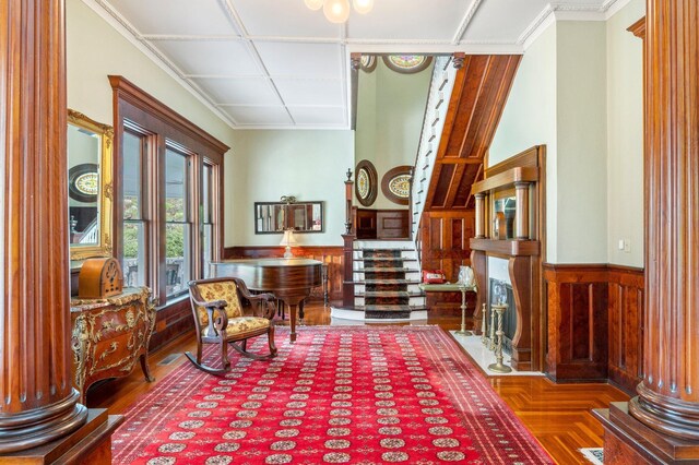 sitting room with ornamental molding and ornate columns