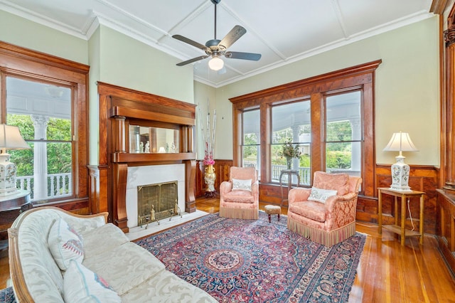 living room with ceiling fan, a fireplace, coffered ceiling, and a healthy amount of sunlight