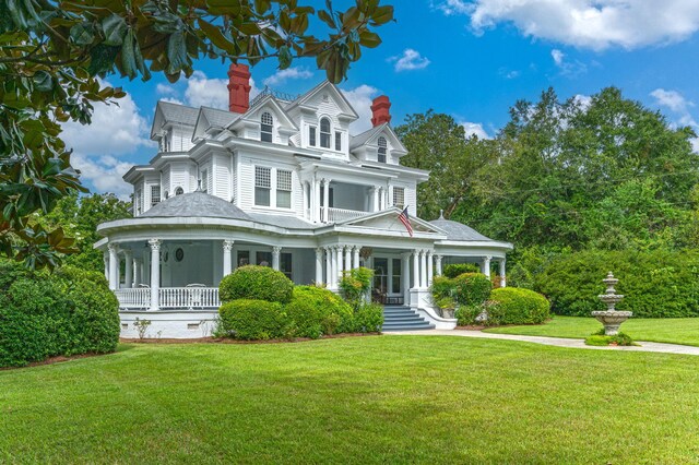 victorian-style house with a front lawn and a porch