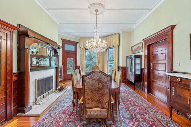 dining space with light hardwood / wood-style floors, crown molding, and a notable chandelier