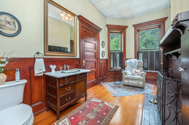 bathroom with hardwood / wood-style floors, vanity, and toilet