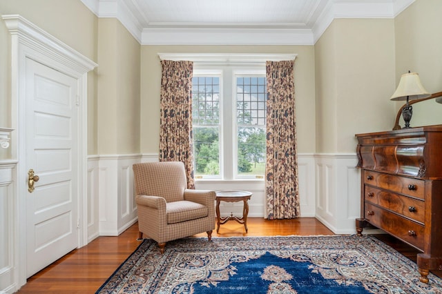 living area featuring wood-type flooring and crown molding