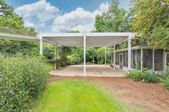 view of yard with a sunroom and a patio area