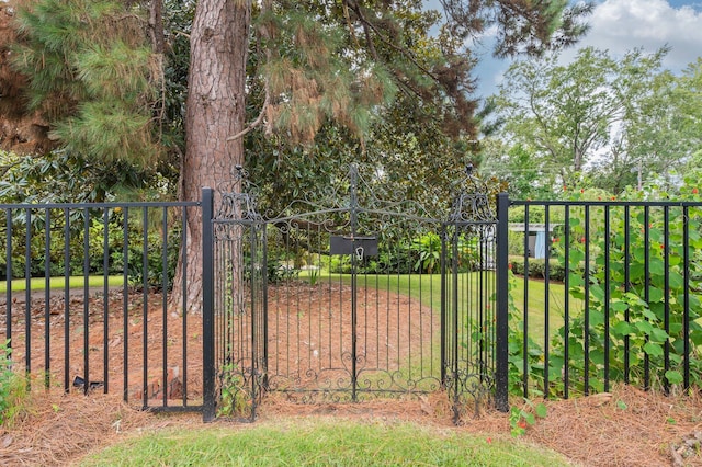 view of gate with a lawn